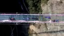Sejumlah pasangan berciuman diatas sebuah jembatan kaca saat mengikuti kontes berciuman di Hari Valentine di Pingjiang, Provinsi Hunan, China (14/2). Kontes ini digelar untuk merayakan hari valentine yang jatuh pada setiap tanggal 14 Februari. (STR / AFP)