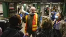 Seorang pejabat MTA membantu mengarahkan penumpang di stasiun kereta bawah tanah di New York, 12 April 2022. Sejumlah orang terluka dalam penembakan yang terjadi pada jam sibuk. (AP Photo/Seth Wenig)