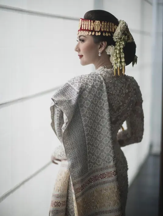 Tak lupa, penampilan pengantin khas Batak dari Jessica Mila. Ia tampil mengenakan kebaya panjang berwarna putih yang super cantik, dilengkapi dengan sortali atau penutup kepala berwarna merah yang khas pada pengantin Batak dan tentunya kain Ulos yang disampirkannya di salah satu bahunya. Foto: Instagram.