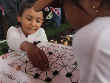 Anak-anak mencoba permainan tradisional di acara Teras Main Indonesia 2025 di Taman Mini Indonesia Indah (TMII), Jakarta, Sabtu (15/11/2025). Sebagai upaya pelestarian budaya, Komite Permainan Rakyat dan Olahraga Tradisional Indonesia (KPOTI) menggelar festival permainan tradisional bertajuk Teras Main Indonesia 2025. (merdeka.com/Arie Basuki)