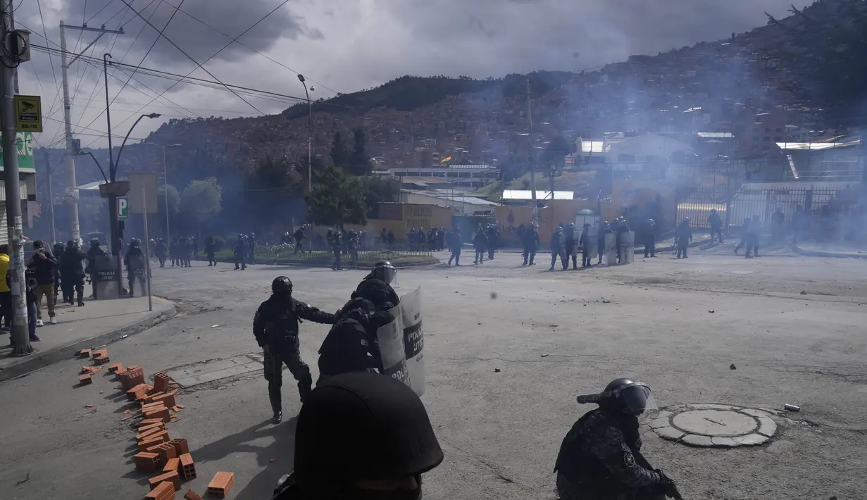 Polisi membubarkan petani koka yang melempar batu dengan gas air mata, di dekat pasar koka di La Paz, Bolivia, Kamis (23/9/2021). Para petani koka anti-pemerintah  melakukan unjuk rasa terhadap perubahan pasar tradisional koka. (AP Photo/Juan Karita)