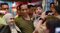 Warga foto bersama Presiden Joko Widodo dan cucunya Jan Ethes di mal Botani Square, Bogor, (8/12). Presiden tampil berkaos hijau dengan celana jins dan sepatu sneakers. sang cucu mengenakan kaos garis-garis. (Liputan6.com/HO/Biro Pers Setpres)
