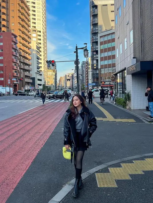 OOTD musim dingin Salshabilla Adriani pakai outfit serba hitam. Ia memadukan inner berkerah abu-abu dengan jaket kulit hitam oversized, mini skirt, stoking transparan, dan high boots yang semuanya berwarna hitam. [Foto: Instagram/salshabillaadr]