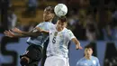 Pemain Argentina, Nahuel Molina berebut bola udara dengan pemain Uruguay, Martin Caceres selama pertandingan penyisihan Piala Dunia di Estadio Campeon del Siglo, Montevideo, Uruguay, Sabtu (13/11/2021). Argentin kini duduk di posisi kedua dengan 28 poin dari 12 laga. (Ernesto Ryan/Pool Via AP)