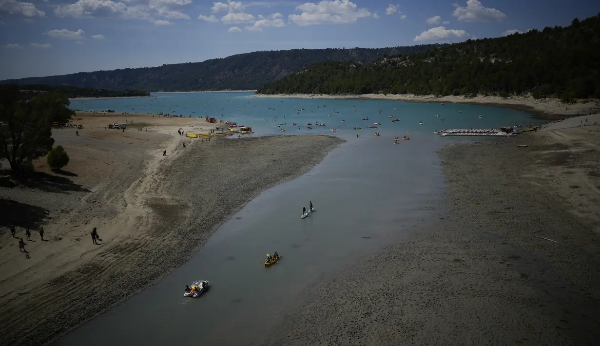 Orang-orang menikmati aktivitas air saat permukaan air terus menurun di Verdon Gorge, Prancis selatan (9/8/2022). Badan cuaca nasional Meteo France mengatakan, gelombang panas dimulai di selatan dan diperkirakan akan menyebar ke seluruh negeri dan berlangsung hingga akhir pekan.  (AP Photo/Daniel Cole)