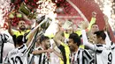 Para pemain Juventus mengangkat Piala merayakan gelar juara Coppa Italia 2020-2021 usai laga final melawan Atalanta di Stadion Mapei, Kamis (20/5/2021) dinihari WIB. Juventus semakin menegaskan diri sebagai raja Coppa Italia dengan koleksi 14 gelar juara. (AP Photo/Antonio Calanni)