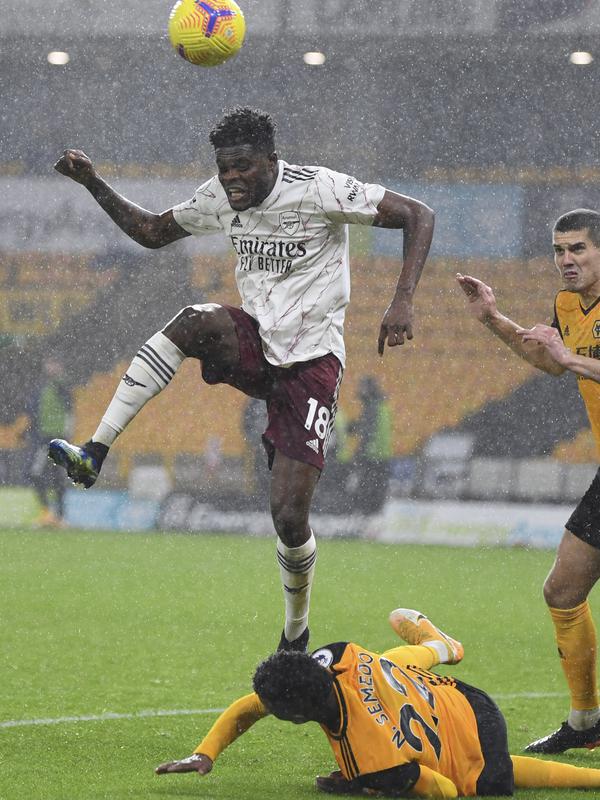 Gelandang Arsenal, Thomas Partey berebut bola dengan bek Wolverhampton Wanderers, Nelson Semedo pada pekan ke-22 Liga Inggris di stadion Mollineux, Rabu (3/2/2021) dini hari WIB. Arsenal harus pulang dengan tangan hampa usai kalah 1-2 atas Wolverhampton. (Shaun Botterill/Pool via AP)