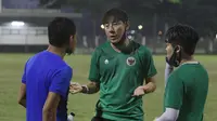 Pelatih Timnas Indonesia, Shin Tae-yong berbincang dengan Evan Dimas saat sesi latihan jelang Piala AFF di Lapangan B Senayan, Jakarta, Selasa (9/11/2021). (Bola.com/M Iqbal Ichsan)