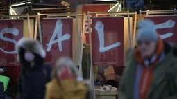 Para pembeli di Oxford Street berjalan melewati tanda obral di etalase toko setelah Bank of England menaikkan Suku Bunga Dasar sebesar 0,5 persen menjadi 3,5 persen di London, Kamis (15/12/2022). Kenaikan ini berarti membuat pembayaran hipotek menjadi lebih tinggi untuk beberapa pemilik rumah dan mereka yang memiliki pinjaman pada saat banyak orang berjuang dengan biaya hidup. (AP Photo/Alastair Grant)