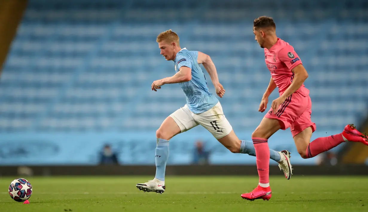 Gelandang Manchester City, Kevin De Bruyne, berebut bola dengan gelandang Real Madrid, Federico Valverde, pada laga leg kedua 16 besar Liga Champions di Etihad Stadium, Sabtu (8/8/2020) dini hari WIB. Manchester City menang 2-1 atas Real Madrid. (AFP/Nick Potts/pool)