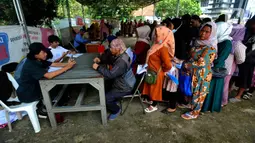 Petugas melayani warga saat penyaluran bantuan langsung tunai (BLT) Kemensos di Kecamatan Ciseeng, Bogor, Jawa Barat, Senin (28/11/2022). Setiap Keluarga Penerima Manfaat (KPM) mendapat BLT BBM sebesar Rp300ribu, Sembako Rp600 ribu dan bantuan PKH (Program Keluarga Harapan) sebesar Rp600 ribu. (merdeka.com/Arie Basuki)