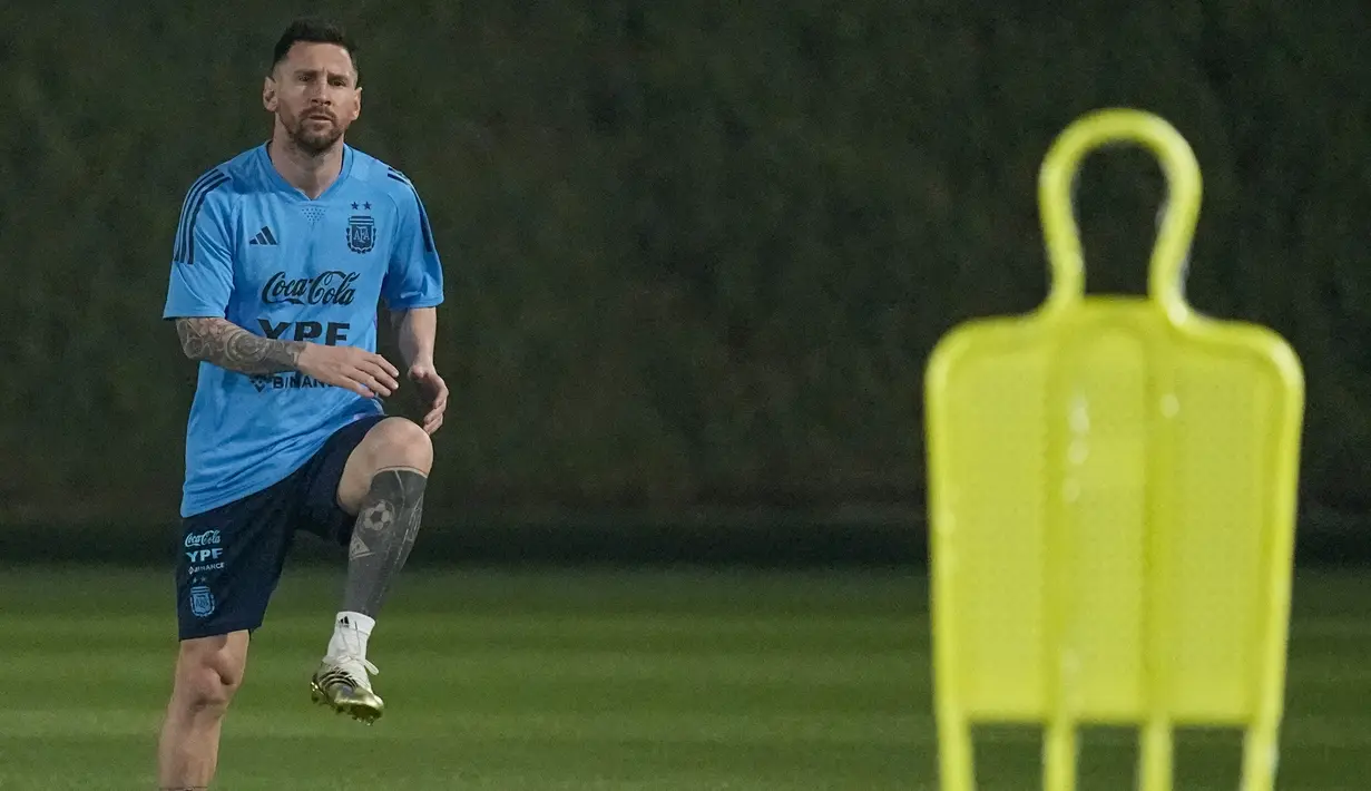 Bintang timnas Argentina Lionel Messi melakukan peregangan saat sesi latihan di Doha, Qatar, Sabtu (19/11/2022). Lionel Messi diharapkan publik Argentina untuk merebut gelar juara Piala Dunia yang terakhir mereka boyong pada 1986 di bawah pimpinan pemain bintang Diego Maradona. (AP Photo/Jorge Saenz)