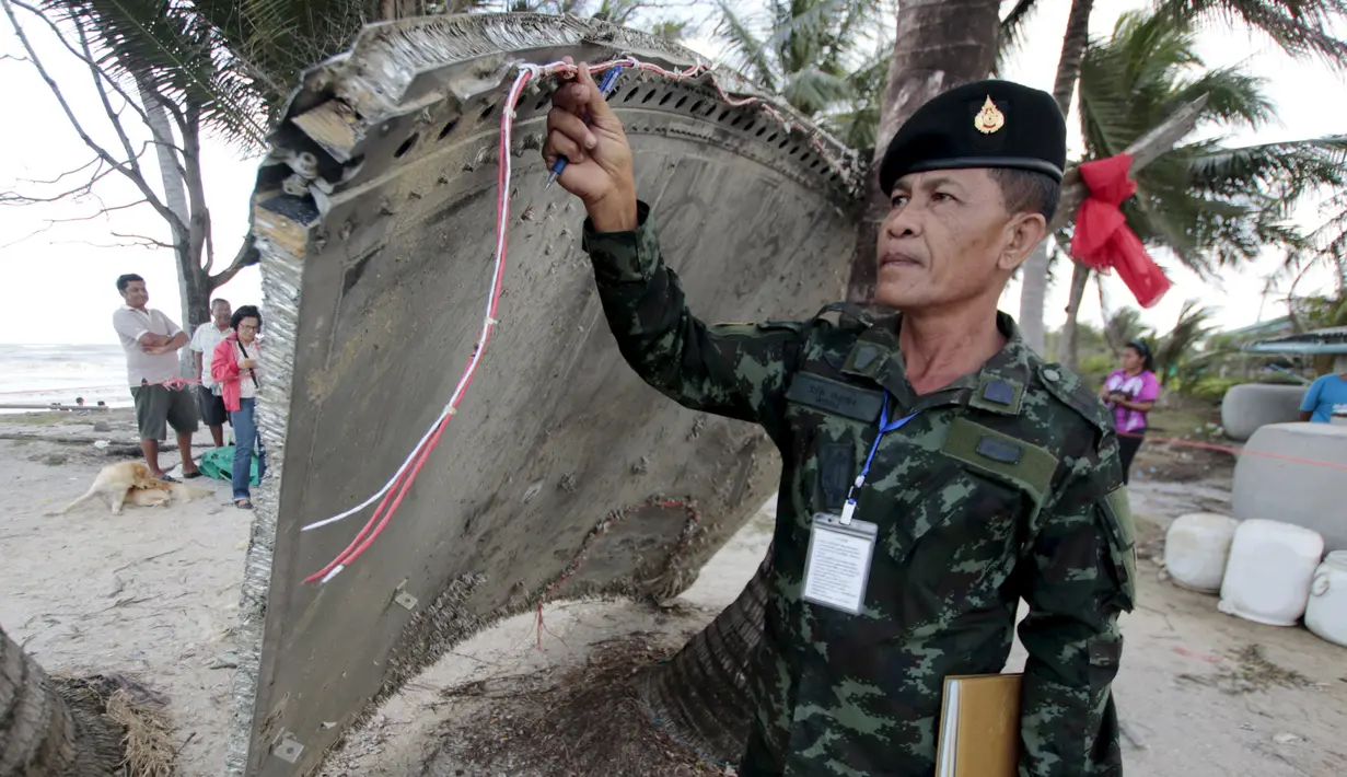 Tentara memeriksa potongan pesawat yang ditemukan di pantai Thailand selatan, provinsi Nakhon Si Thammarat, Minggu (24/1). Sebuah bagian pesawat yang diduga dari pesawat Malaysia Airlines MH370 ditemukan oleh warga sekitar. (REUTERS/Surapan Boonthanom)