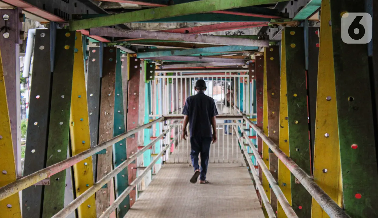 Penutupan ini membuat warga kesulitan menyeberang dengan melintasi jembatan yang menghubungkan dua daerah yang dibatasi aliran sungai Ciliwung. (Magang/Liputan6.com/Muhammad Rizal)