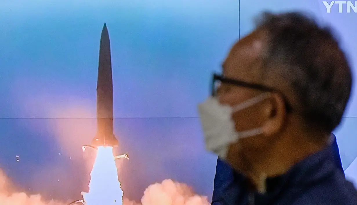 Seorang pria berdiri di dekat layar televisi yang menayangkan siaran berita dengan rekaman file uji coba rudal Korea Utara, di sebuah stasiun kereta api di Seoul, Korea Selatan, Minggu (9/10/2022). Peluncuran pertama dilakukan sekitar pukul 01.47 pagi waktu setempat dan yang kedua sekitar enam menit kemudian. (ANTHONY WALLACE / AFP)