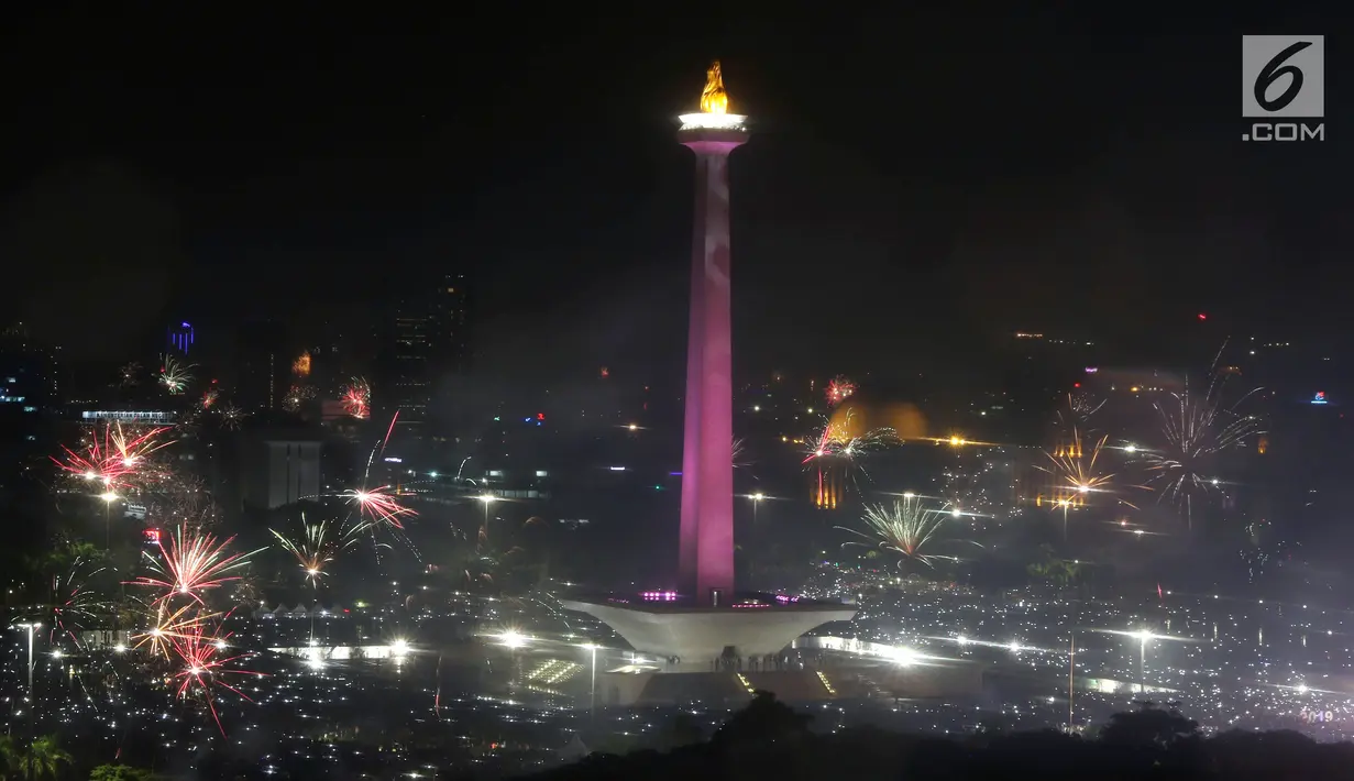 <p>Kembang api menyala menyambut pergantian tahun 2018 ke 2019 di kawasan Monumen Nasional, Jakarta, Selasa (1/1). Hujan yang mengguyur Jakarta tidak menyurutkan warga menikmati kembang api tahun baru. (Liputan6.com/Helmi Fithriansyah)</p>