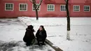 Dua orang wanita mengobrol di bawah pohon di Pyongyang, Korea Utara, Minggu (16/12). Korea Utara saat ini mulai memasuki musim dingin. (AP Photo/Dita Alangkara)