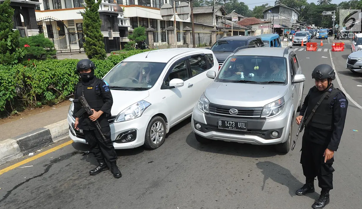 Aparat kepolisian bersenjata laras panjang melakukan pengamanan di ruas jalan menuju Puncak di Tanjakan Selarong, Bogor, Kamis (6/6/2019). Memasuki lebaran hari kedua, beberapa titik di kawasan Puncak mengalami kemacetan akibat tingginya tingkat kunjungan wisatawan domestik (merdeka.com/Arie Basuki)