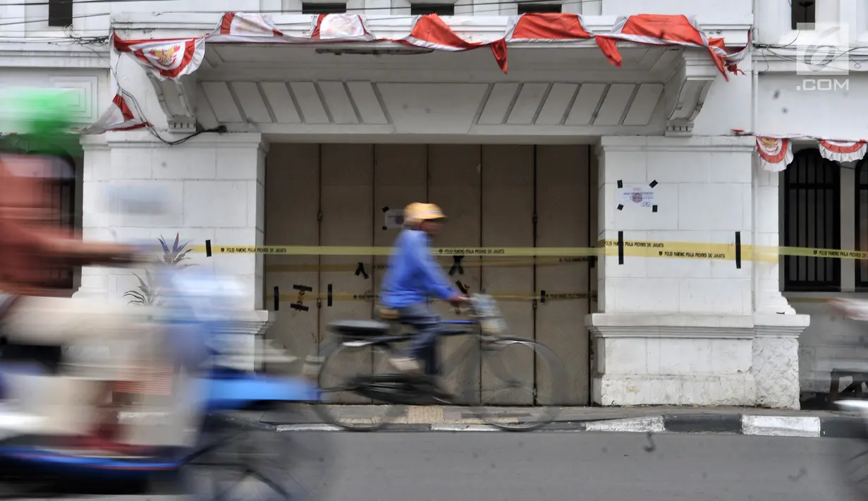 Pesepeda melintas di depan Diskotek Old City yang disegel oleh Satpol PP di Jakarta, Selasa (23/10). Satpol PP DKI menutup sementara Diskotek Old City tadi malam karena adanya penemuan pemakaian narkoba di lokasi tersebut. (Merdeka.com/Iqbal S. Nugroho)