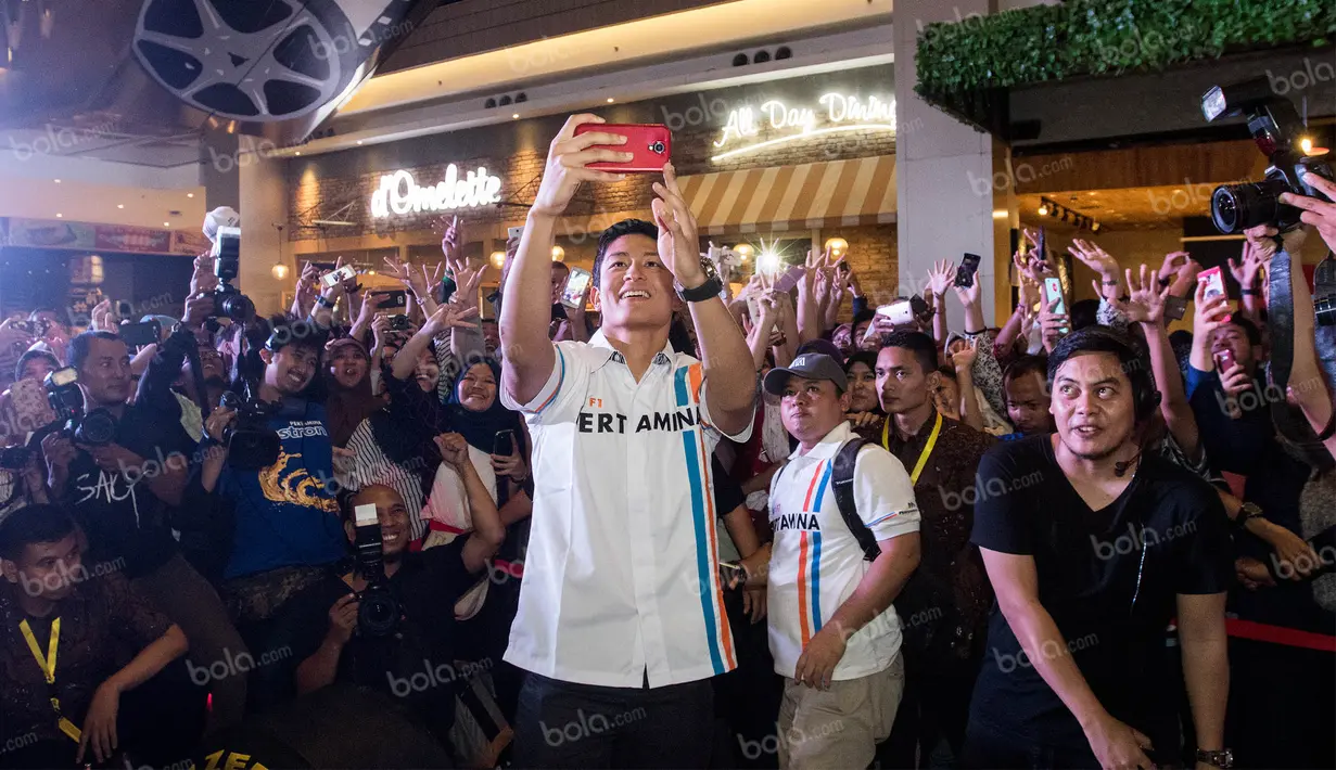 Pebalap F1 pertama asal Indonesia, Rio Haryanto, tampak antusias melakukan selfie bersama para penggemarnya di Mall Kota Kasablanka, Jakarta, Kamis (7/4/2016). (Bola.com/Vitalis Yogi Trisna)