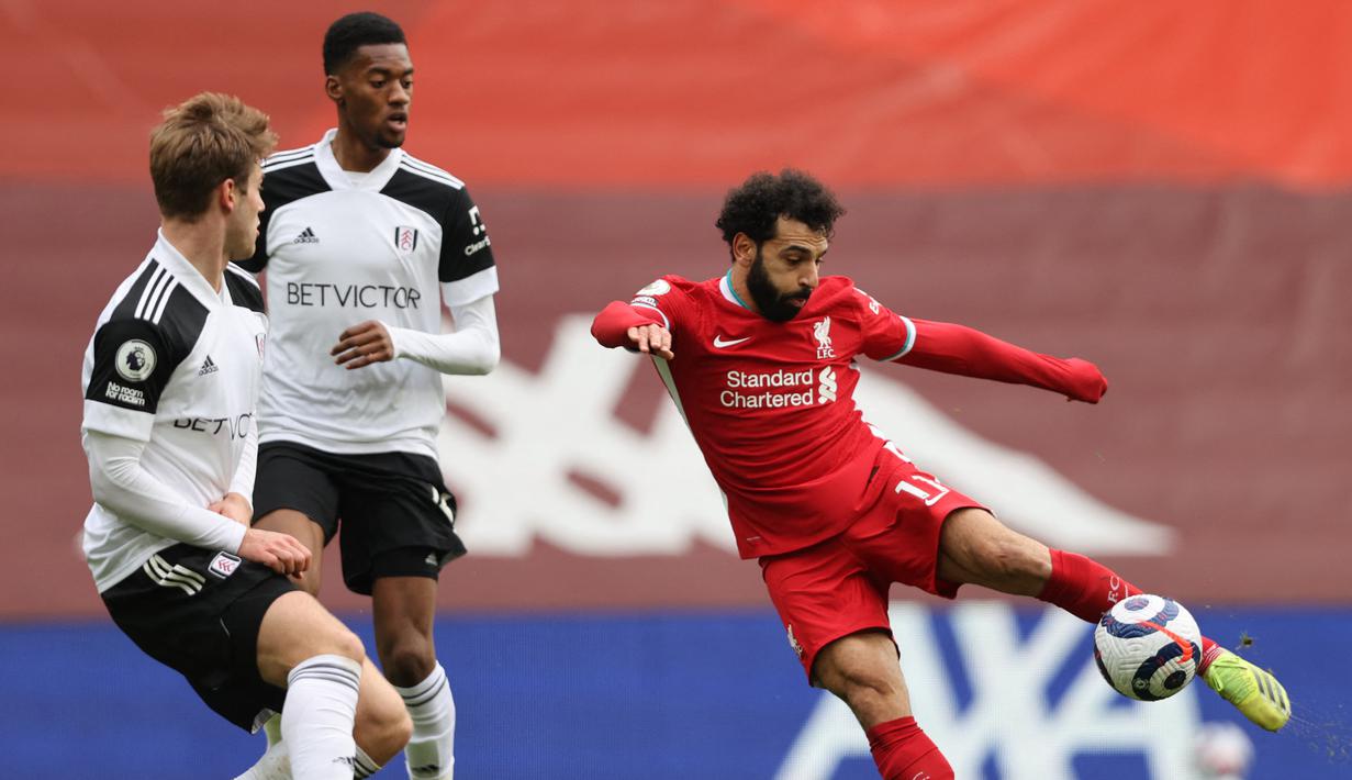 Gelandang Liverpool, Mohamed Salah (kanan) melepaskan tendangan yang masih melenceng dari gawang Fulham dalam laga lanjutan Liga Inggris 2020/21 di Anfield Stadium, Minggu (7/3/2021). Liverpool kalah 0-1 dari Fulham. (AFP/Clive Brunskill/Pool)