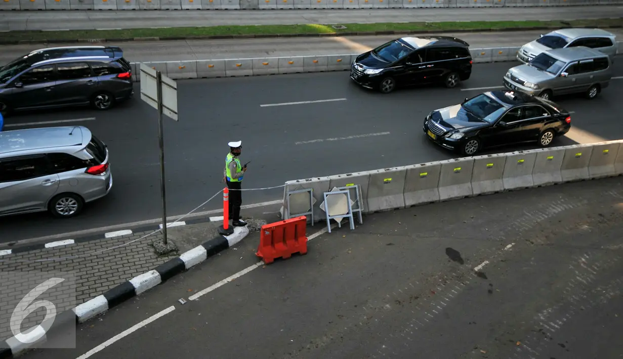 Petugas mengatur kendaraan yang melintas di Jalan Jenderal Sudirman, Semanggi, Jakarta, Rabu (8/6/2016). Jalur cepat dari arah Sudirman menuju Cawang ditutup sementara terkait pengerjaan proyek pembangunan jembatan layang. (Liputan6.com/Yoppy Renato)
