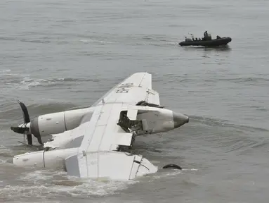 Pasukan keamanan berlayar di lepas pantai Port-Bouet,di dekat lokasi jatuhnya pesawat kargo Antonov yang menewaskan 4 orang warga Moldovan di Abidjan (14/10). Pesawat tersebut jatuh akibat dihantam ombak Pantai Gading. (AFP PHOTO / Sia KAMBOU)