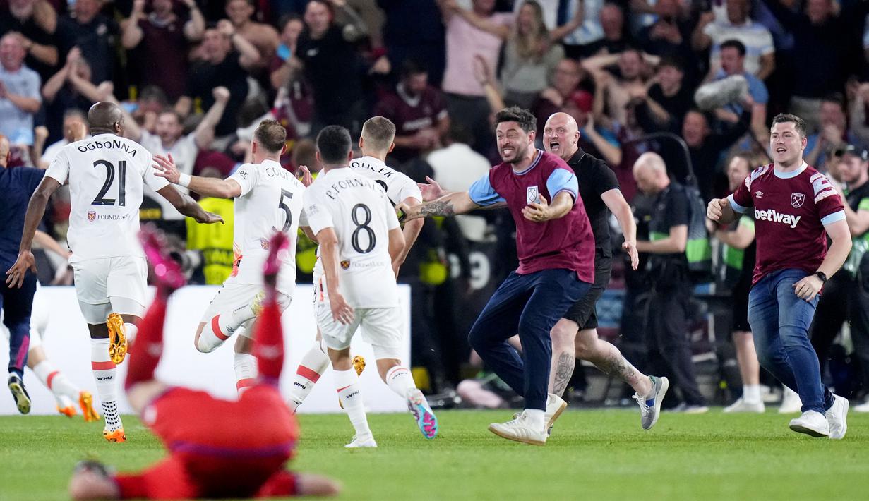 Suporter turun ke lapangan saat merayakan keberhasilan West Ham United menjuarai UEFA Europa Conference League di Stadion Eden Arena, Kamis (8/6/2023). West Ham menang dengan skor 2-1. (AP Photo/Petr David Josek)