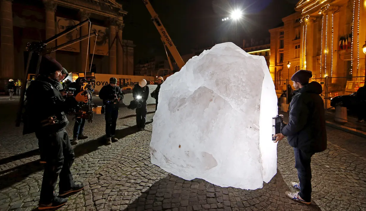 Wartawan saat mengambil gambar balok es berukuran yang ada ditengah kota  Paris, Perancis, Kamis (3/12). Balok es ini diambil langsung dari daerah Greenland. (REUTERS/Benoit Tessier)