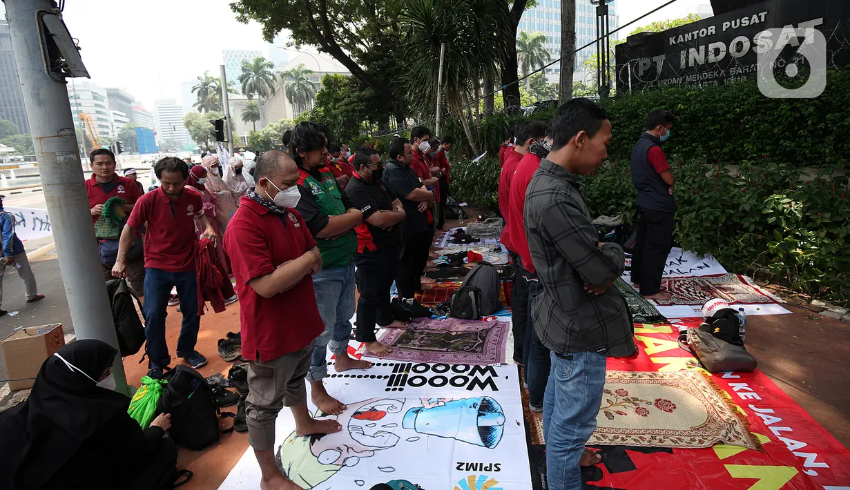 Karyawan IndosatM2 salat saat demonstrasi di depan Gedung PT Indosat, Jalan Merdeka Barat, Jakarta Pusat, Rabu (22/12/2021). Demonstran meminta karyawan yang telah di-PHK untuk diperkerjakan kembali tanpa syarat serta menuntut Indosat membayar dan memenuhi hak-hak karyawan. (Liputan6.cm/Johan Tallo)