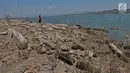 Wisatawan melintasi kompleks makam lama yang muncul ke permukaan Waduk Gajah Mungkur di Wonogiri, Selasa (2/9/2019). Setiap musim kemarau, makam lama milik warga yang rumahnya tergusur proyek pembangunan waduk pada tahun 1978-1980 itu muncul saat volume air waduk menyusut (merdeka.com/Iqbal Nugroho)