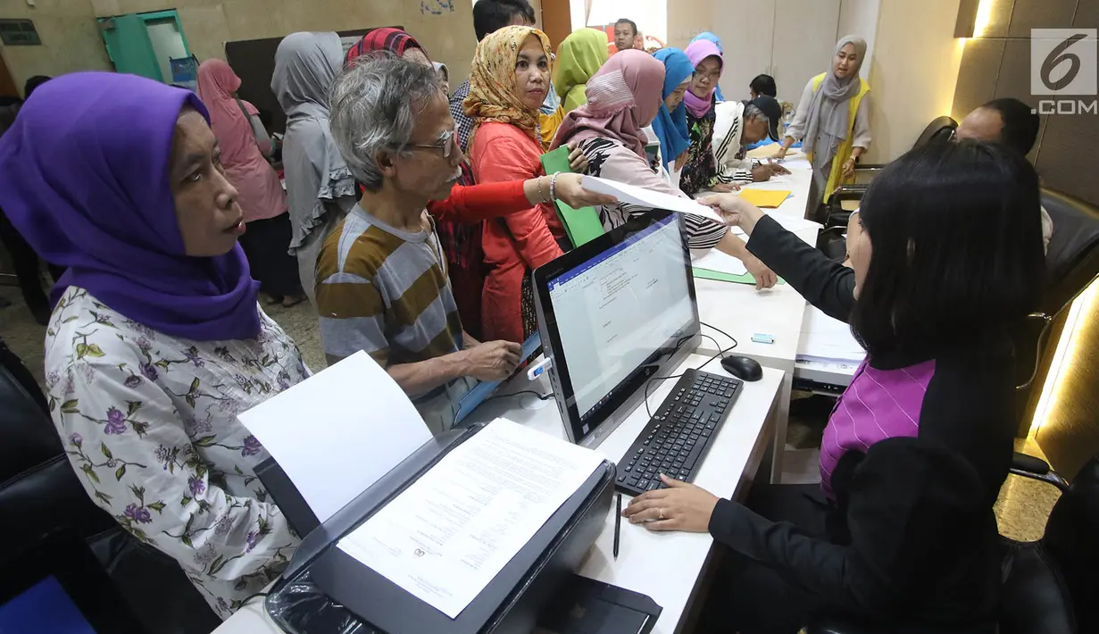 Petugas melayani Korban dugaan penipuan perjalanan umrah First Travel mengisi formulir di Posko Pengaduan Korban PT First Travel Bareskrim Polri, Jakarta, Senin (21/8). (Liputan6.com/Immanuel Antonius)