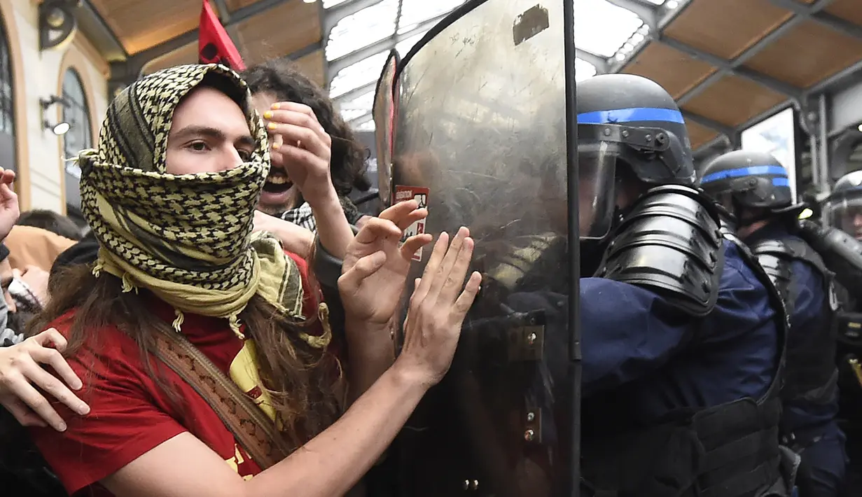 Aksi saling dorong antara demonstran dan polisi di dekat Stasiun Saint-Lazare, Paris, Perancis, Selasa (12/4). Demonstran menentang reformasi hukum perburuhan yang dirancang pemerintah Perancis. (AFP Photo/ Dominique Faget)