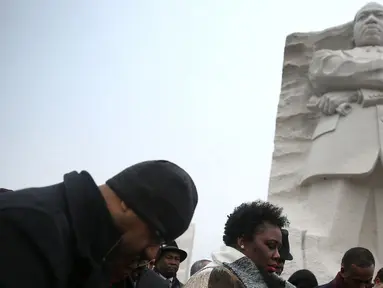 Sejumlah orang berkumpul dan berdoa di depan Patung Martin Luther King Jr, Washington DC, AS, Senin (16/1). Di Amerika Serikat, Senin pada Minggu ketiga diperingati sebagai 'Hari Martin Luther King Jr'. (Joe Raedle / Getty Images / AFP)