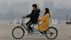 Pasangan naik sepeda menggenakan masker saat pemandangan kota diselimuti kabut tebal partikel debu halus di Seoul, Korea Selatan (5/3). Kementerian Lingkungan Korsel mengeluarkan langkah-langkah penurunan debu halus darurat. (AP Photo/Ahn Young-joon)