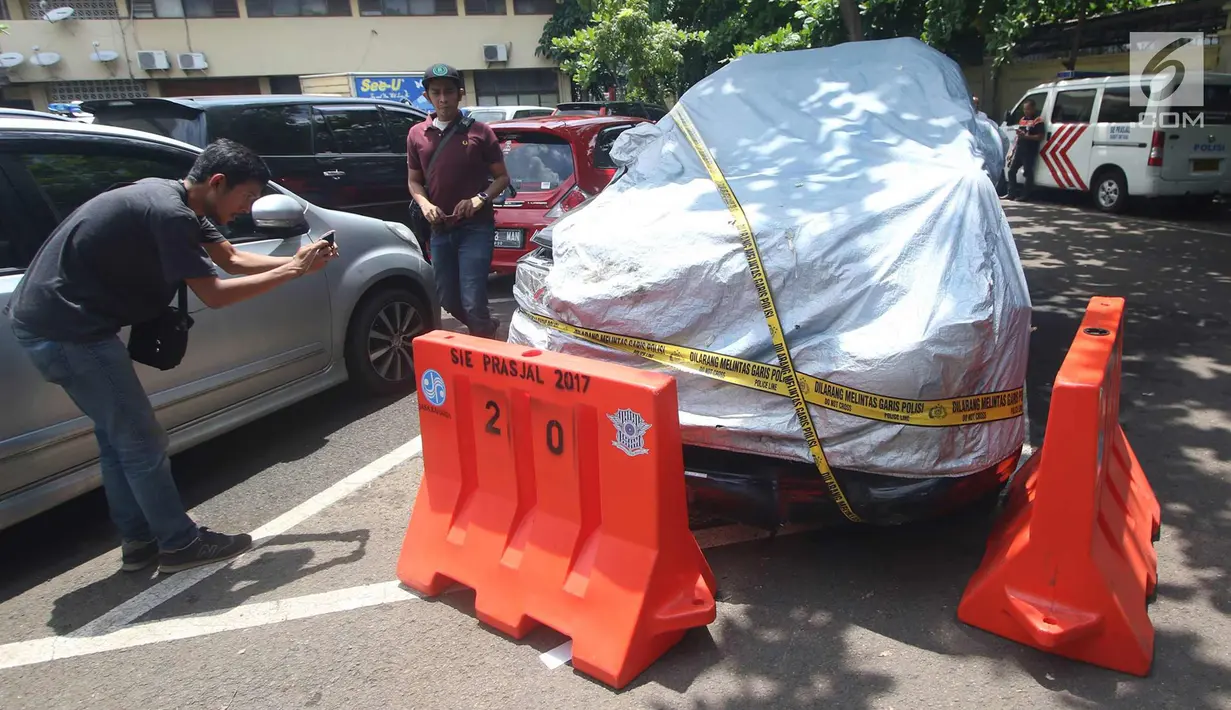 Wartawan memotret mobil yang digunakan Ketua DPR Setya Novanto saat terlibat kecelakaan di Ditlantas Polda Metro Jaya, Jakarta, Jumat (17/11). Akibat kejadian tersebut, Setnov harus dirawat di RS Medika Permata Hijau. (Liputan6.com/Immanuel Antonius)