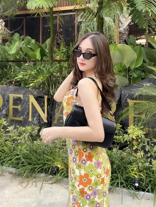 Dalam balutan dress floral, Laura tampak menawan dan stylish.  [Foto: Instagram/ Laura Moane]