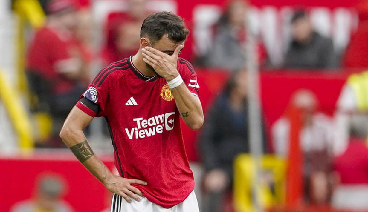 Pemain Manchester United, Bruno Fernandes, menutup wajahnya setelah ditaklukkan Brighton and Hove Albion pada laga Liga Inggris di Stadion Old Trafford, Sabtu (16/9/2023). Setan Merah takluk 1-3 dari Brighton. (AP Photo/Dave Thompson)