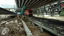 Alat berat dan truk mengangkut tumpukan sampah di jembatan Rawajati Kalibata, Jakarta, Selasa (8/3/2016). Hujan yang mengguyur Bogor dua hari terakhir mengakibatkan banjir kiriman yang disertai sampah batang bambu. (Liputan6.com/Helmi Fithriansyah)