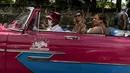 Turis menikmati mojito saat bepergian dengan mobil antik Amerika selama tur kota Varadero, Kuba, pada Rabu (29/9/2021). Pihak berwenang di Kuba mulai melonggarkan pembatasan COVID-19 di beberapa kota seperti Havana dan Varadero. (AP Photo/Ramon Espinosa)