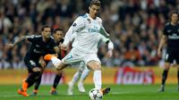 Pemain Real Madrid, Cristiano Ronaldo mencetak gol ke gawang Paris Saint-Germain pada leg pertama babak 16 besar Liga Champions di Stadion Santiago Bernabeu, Rabu (14/2). Dua dari tiga gol Real Madrid disumbangkan Ronaldo. (AP/Paul White)