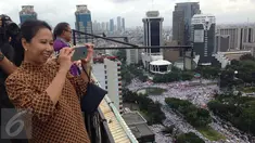 Menteri BUMN, Rini Soemarno mengabadikan gambar demo 2 Desember di atas gedung BUMN, Jakarta, Rabu (2/12). Demo 2 Desember digelar sebagai lanjutan dari aksi 4 November 2016. (Liputan6.com/Ferbian Pradolo)