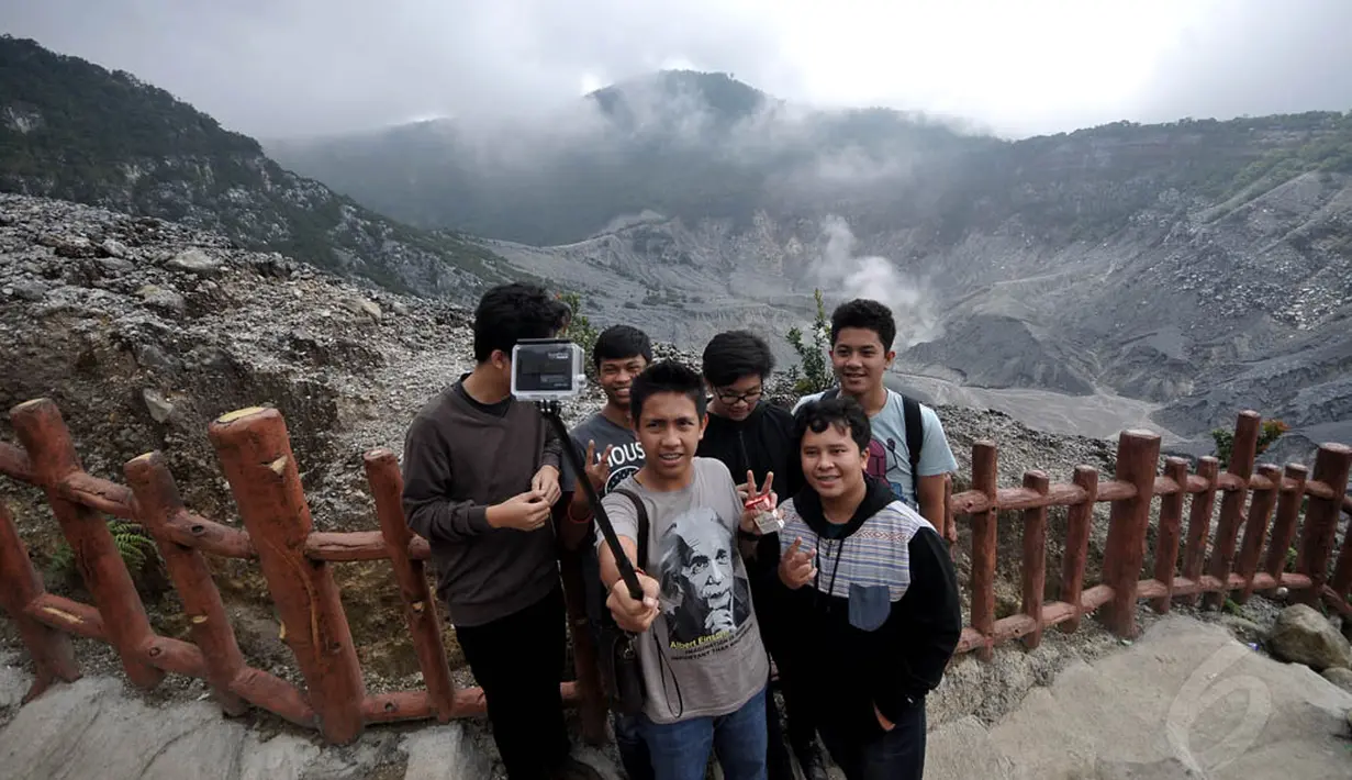 Beberapa pengunjung Tangkuban Perahu tampak berfoto selfi dengan menggunakan tongsis (tongkat narsis) (Liputan6.com/Johan Tallo)