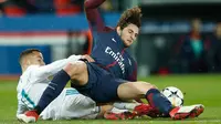 Pemain Real Madrid Lucas Vazquez melakukan sliding kepada Adrien Rabiot saat pertandingan Liga Champions leg kedua di stadion Parc des Princes di Paris (6/3). Real Madrid menang 2-1 atau unggul agregat 5-2 atas PSG. (AP/ Francois Mori)