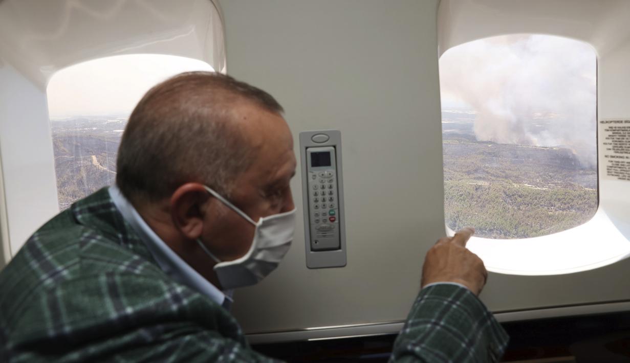 Presiden Turki Recep Tayyip Erdogan menyaksikan dari pesawat kebakaran hutan di Manavgat, Antalya, Turki, Sabtu (31/7/2021). Kebakaran di seluruh Turki sejak Rabu membakar hutan, merambah desa dan tujuan wisata dan memaksa orang untuk mengungsi. (Turkish Presidency via AP, Pool)