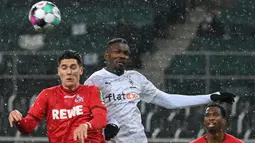 Bek FC Koln, Sava-Arangel Cestic (kiri) berduel udara dengan striker Borussia Moenchengladbach, Marcus Thuram dalam laga lanjutan Liga Jerman 2020/21 pekan ke-20 di Borussia Park, Sabtu (6/2/2021). FC Koln menang 2-1 atas Borussia Moenchengladbach. (AFP/Ina Fassbender/Pool)