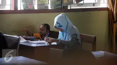 Seorang peserta membawa anaknya saat mengikuti ujian kesetaraan Paket C di SMPN 15 Yogyakarta, Senin (4/4). Sebanyak 447 peserta mengikuti ujian akhir untuk mendapatkan ijazah setingkat SMA. (Liputan6.com/Boy Harjanto)