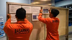 Petugas Basarnas menempel informasi terkait penanganan peristiwa terbakarnya KM Mutiara Sentosa 2 di posko informasi, Gapura Surya Nusantara, Pelabuhan Tanjung Perak, Surabaya, Jawa Timur, Minggu (2/8/2026). (AFP/ Juni Kriswanto)