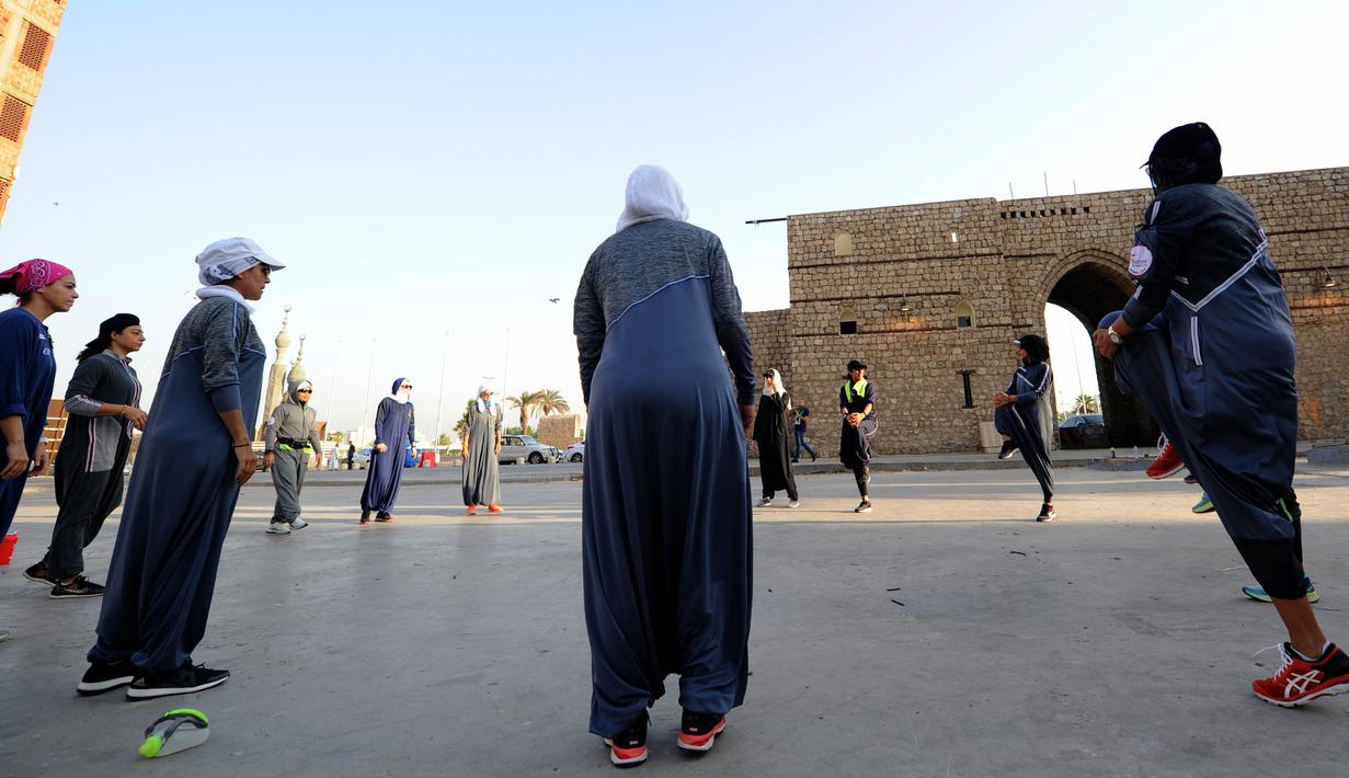 Perempuan Arab Saudi pemanasan sebelum jogging dalam memperingati Women's Day atau Hari Perempuan Internasional di Distrik Al-Balad, Jeddah, Kamis (8/3). Perempuan Arab Saudi menyambut baik sejumlah kebebasan yang diberikan. (Amer HILABI/AFP)