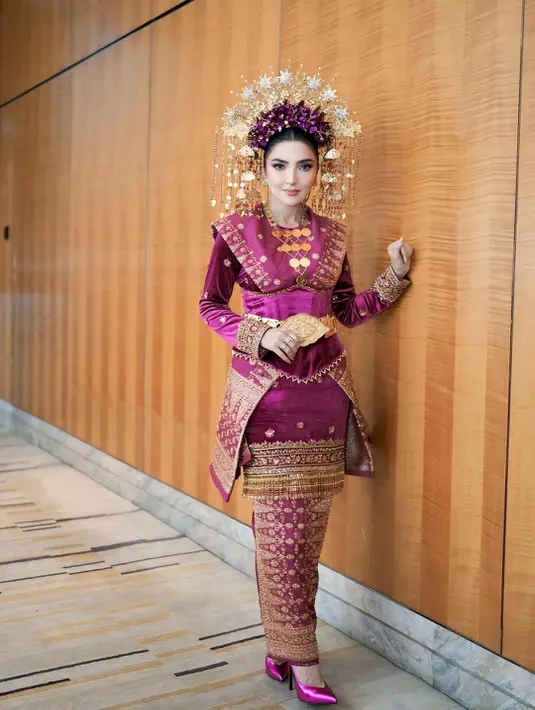 Lengkapi busana adat Komering, Ashanty kenakan headpiece emas dan heels ungu satin yang serasi [@ashanty_ash]